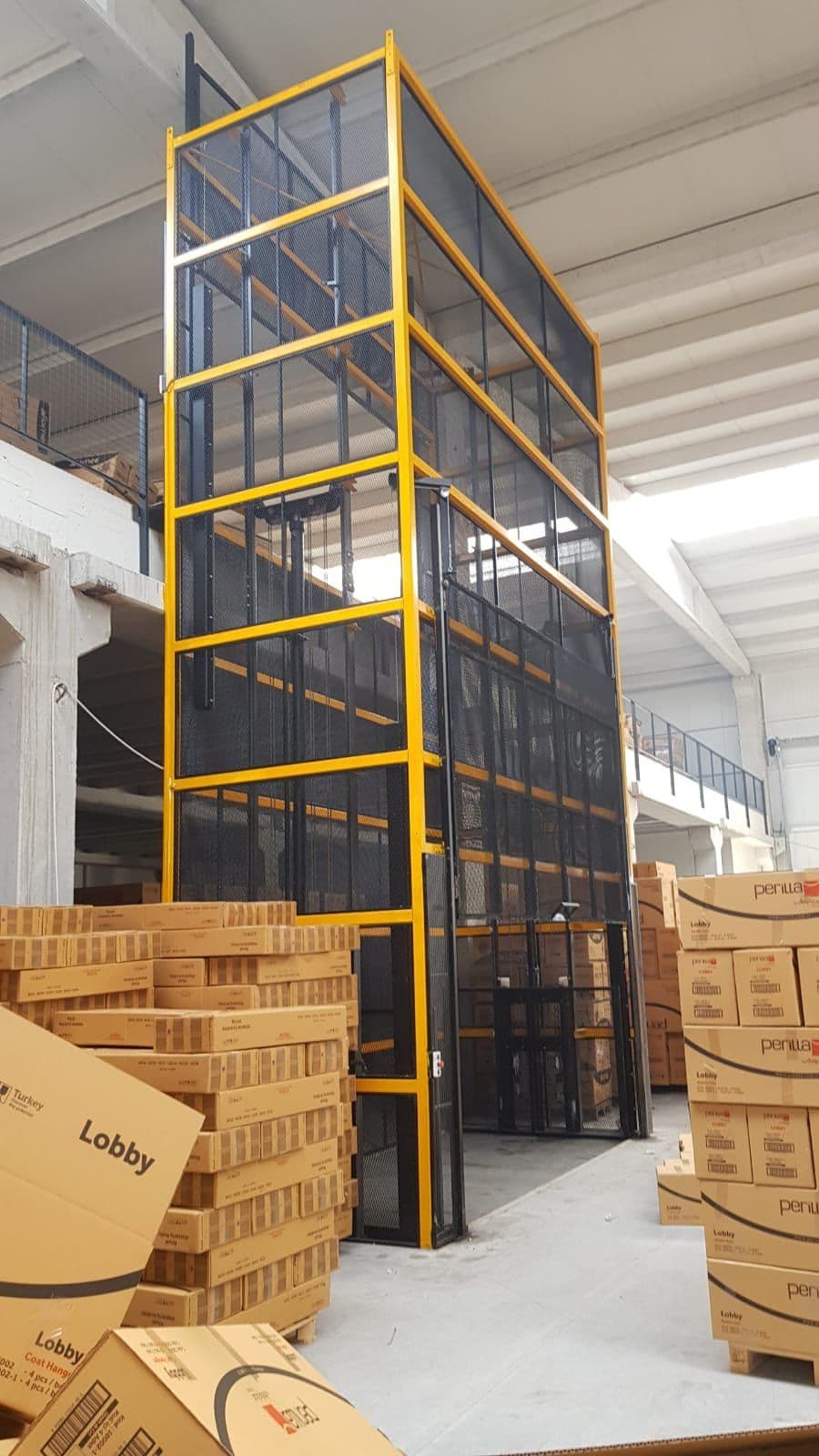 Uzar Lift depo yük asansörü — sarı kafes korumalı çok katlı sistem